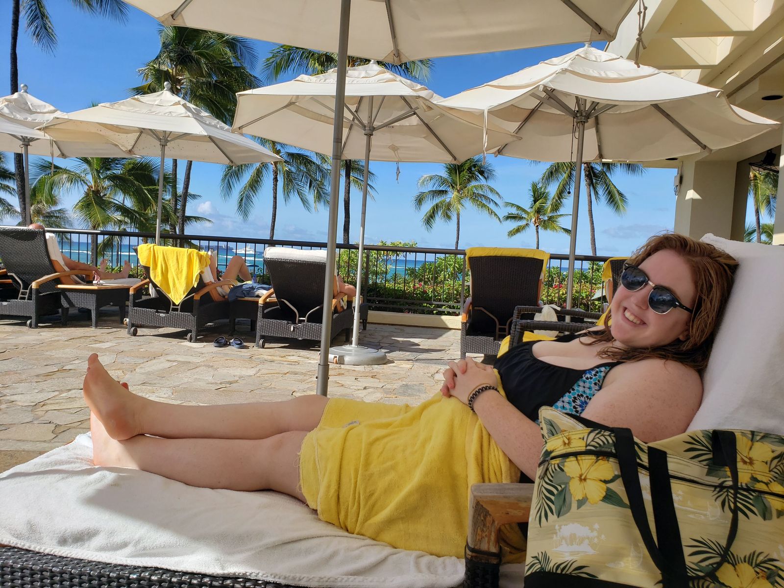 A person relaxing on a beach chair overlooking the ocean, representing serene maternity wellness.