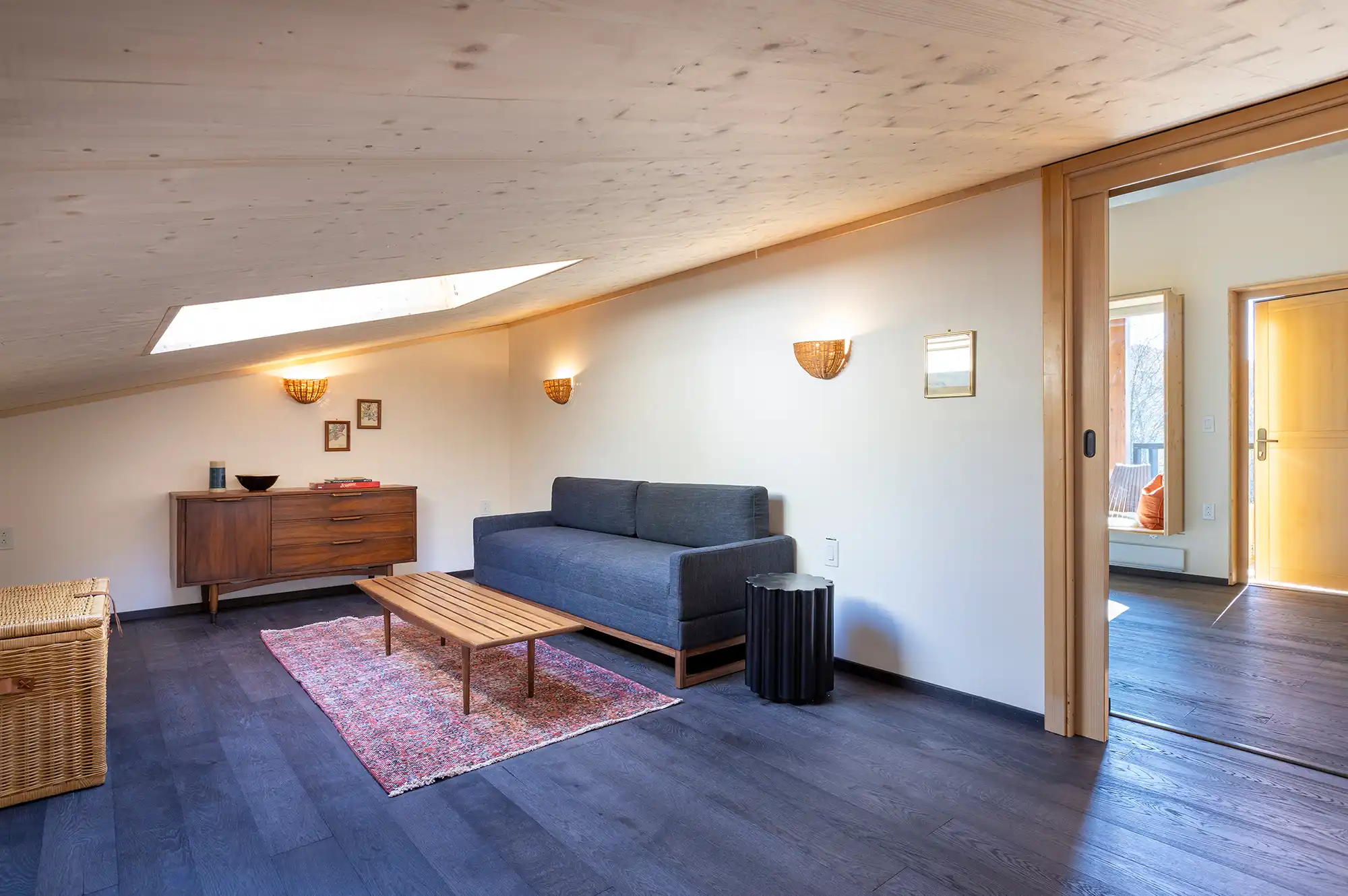 A loft-style hotel room seating area with a sofa and Scandinavian design accents.