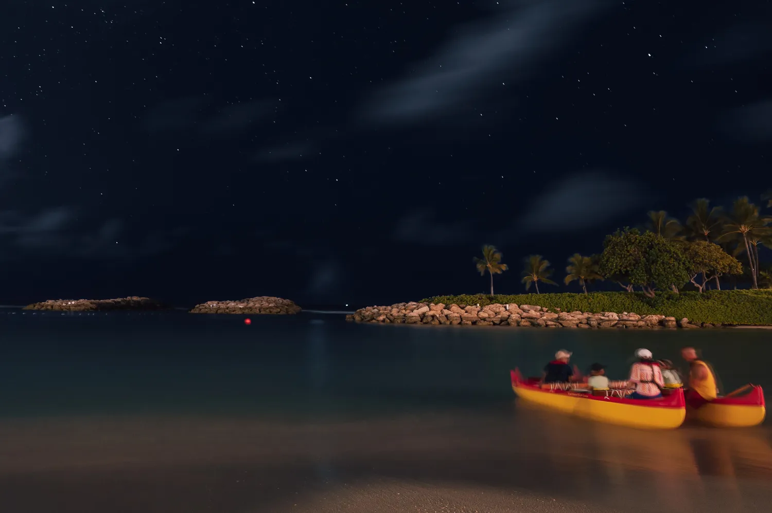 People navigating an outrigger canoe on a calm waterway at night under celestial guidance.