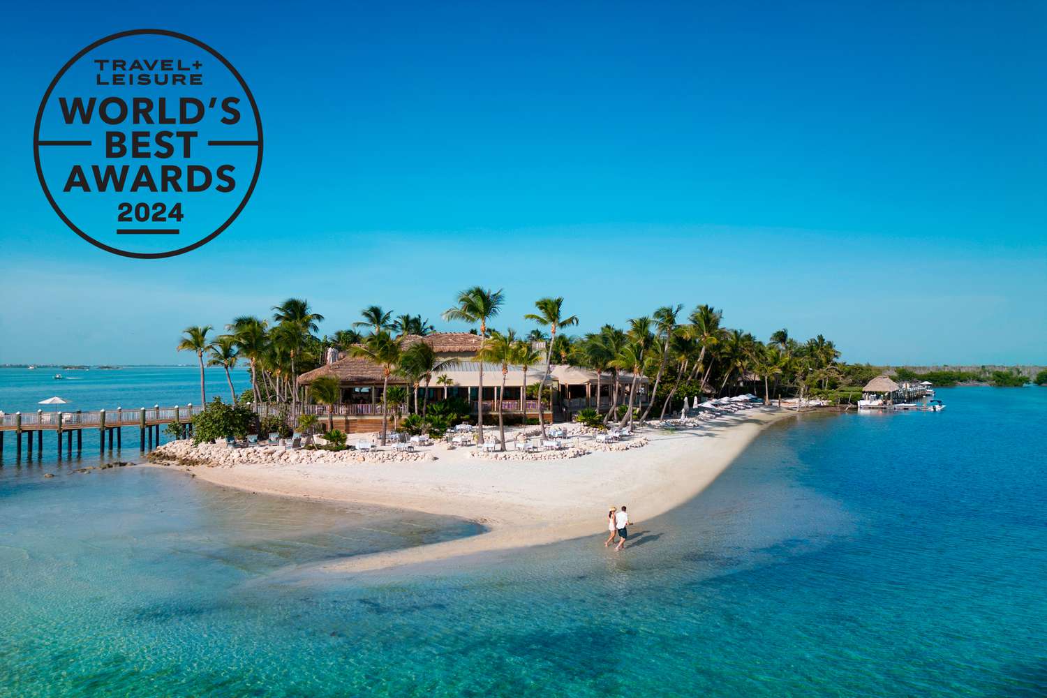 A wide exterior view showcasing the lush palm trees and elite environment of Little Palm Island.