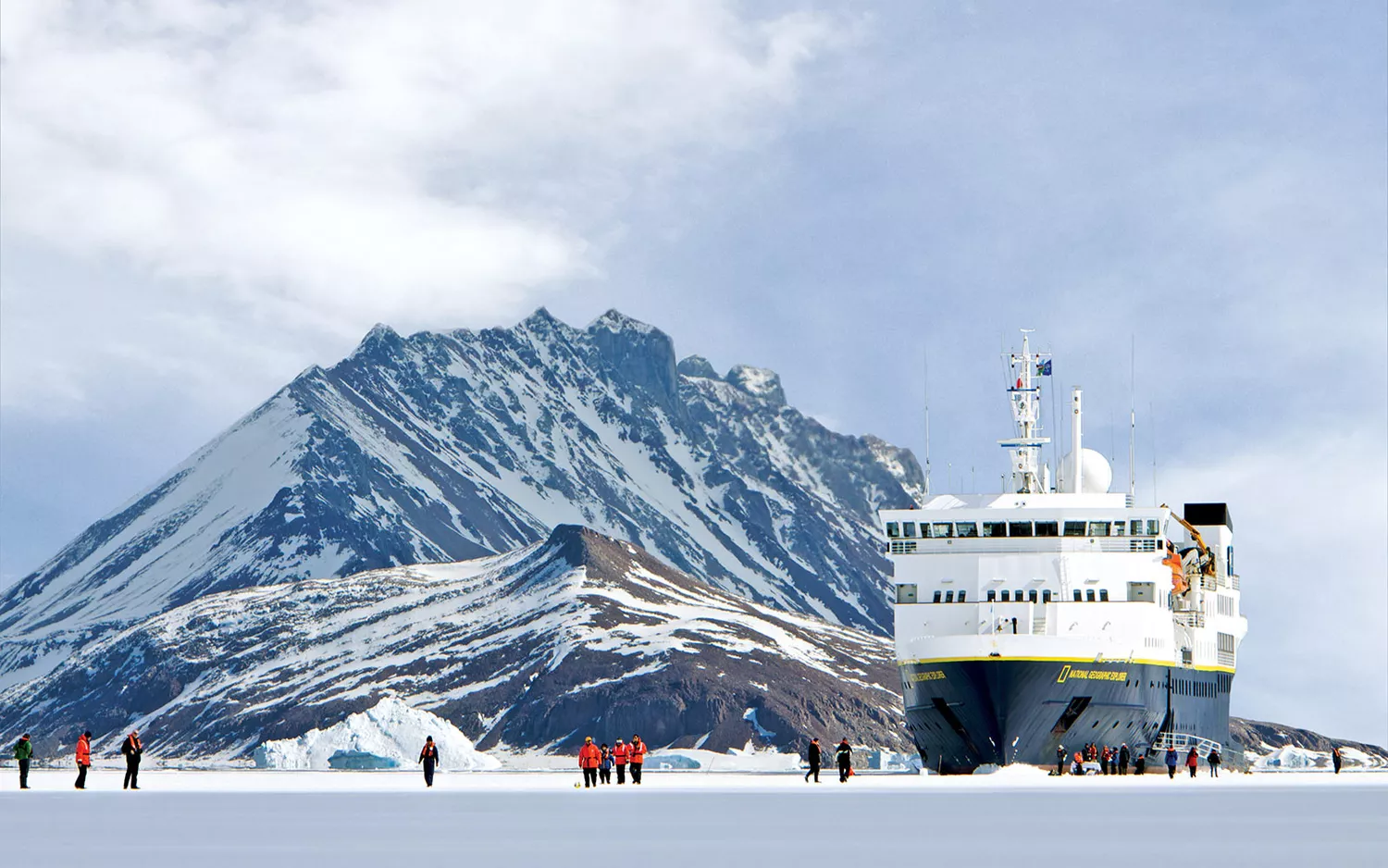 A small expedition cruise ship navigating through ice-filled polar waters.