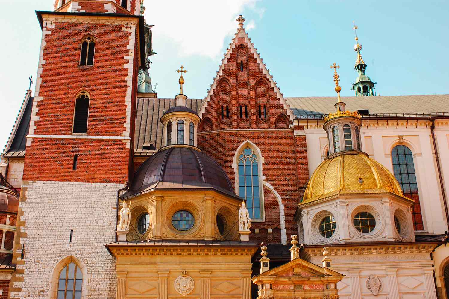Wide shot of a pedestrian street in Krakow's Old Town with clear signage and moderate crowds.