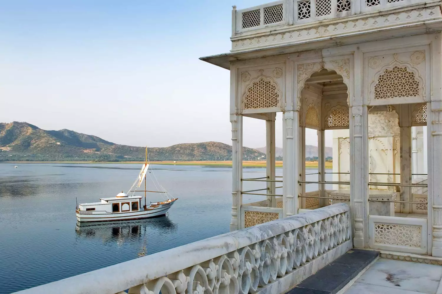 The historic white exterior of Taj Lake Palace on the water