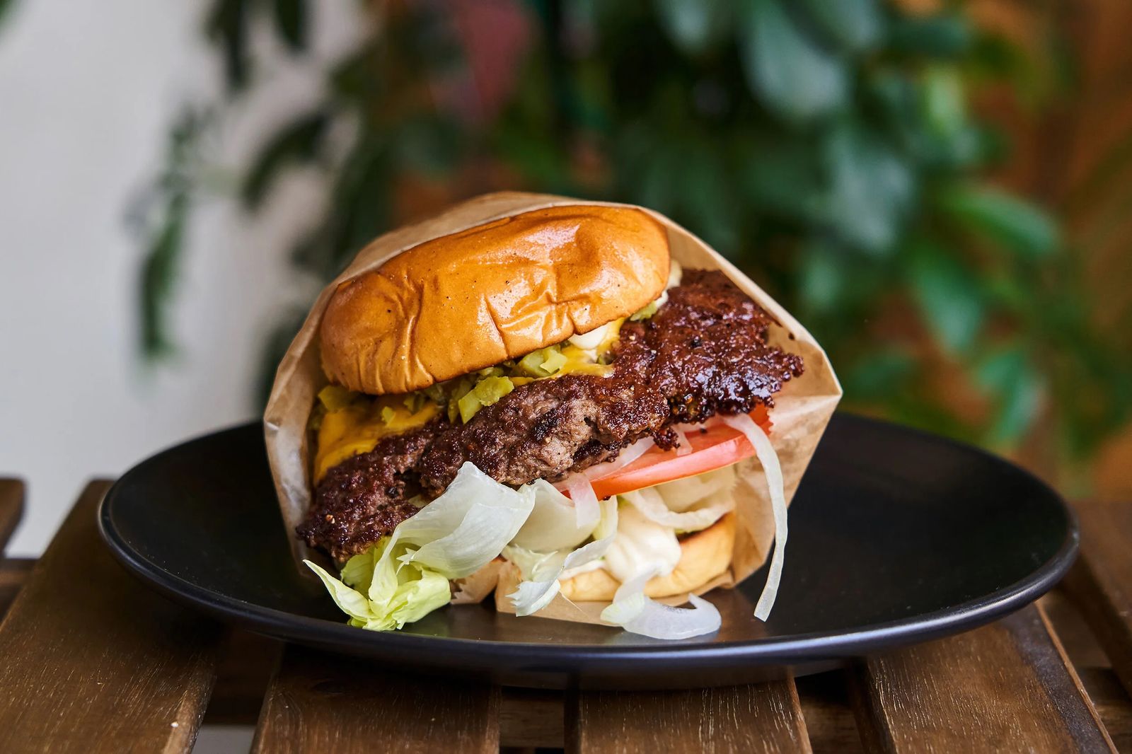 A thick, juicy beef patty burger focusing on the texture and quality of the meat trimmings.