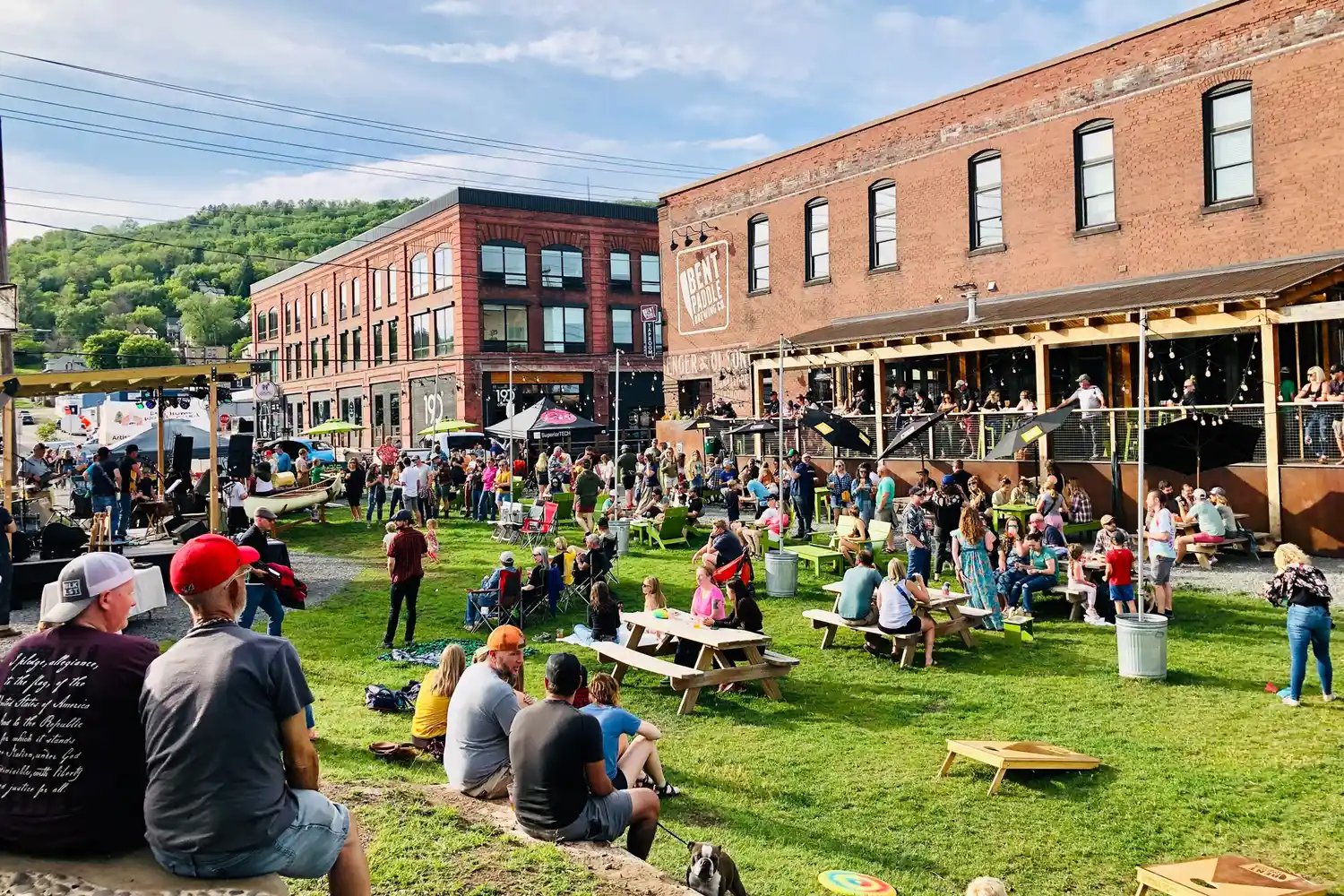 Crowds of people socializing on a large outdoor patio at a craft brewery in Duluth.