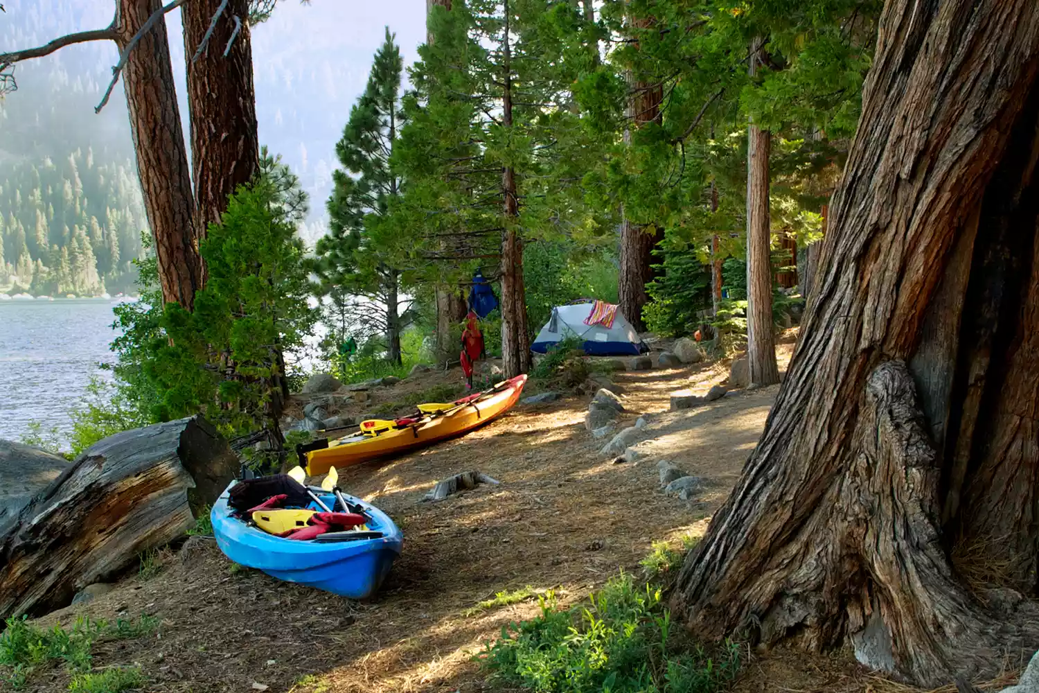 Canoes and a tent pitched at the Emerald Bay Boat Camp in Emerald Bay State Park, California.