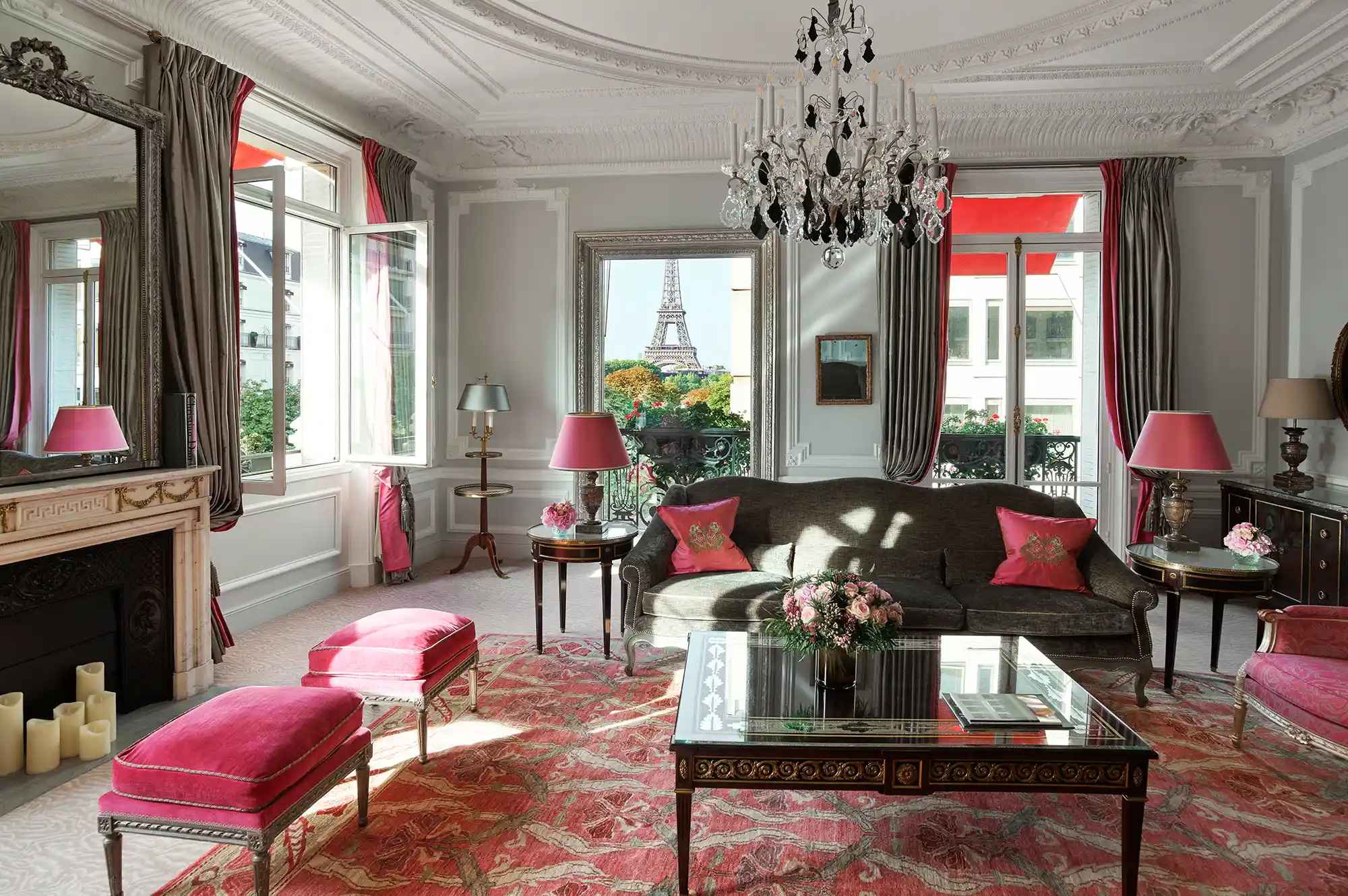 A luxurious suite interior with classic French decor and a large window framing a direct view of the Eiffel Tower.