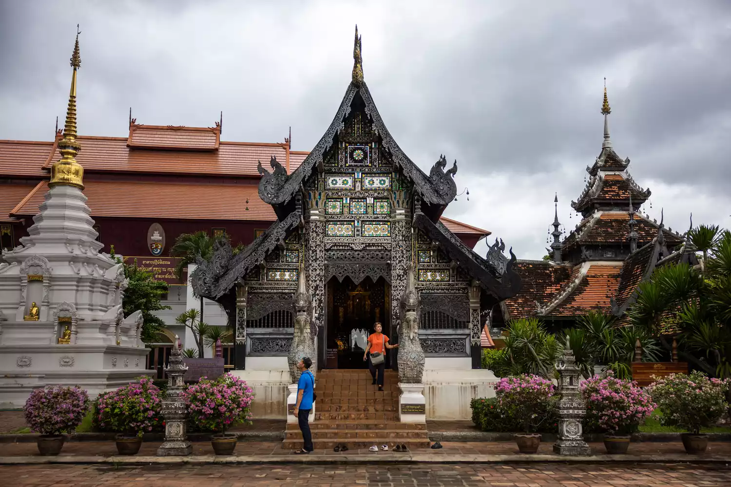 Traditional Buddhist temples in Chiang Mai under a bright blue sky.