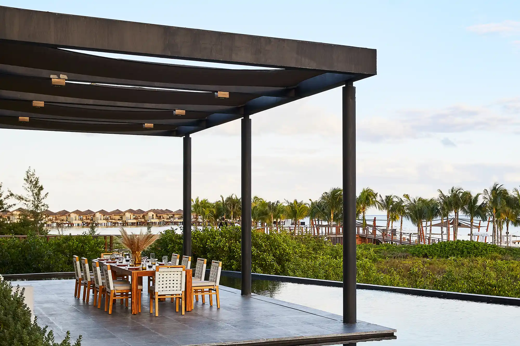 Luxury outdoor dining area under a modern pergola at Etéreo with tropical views.