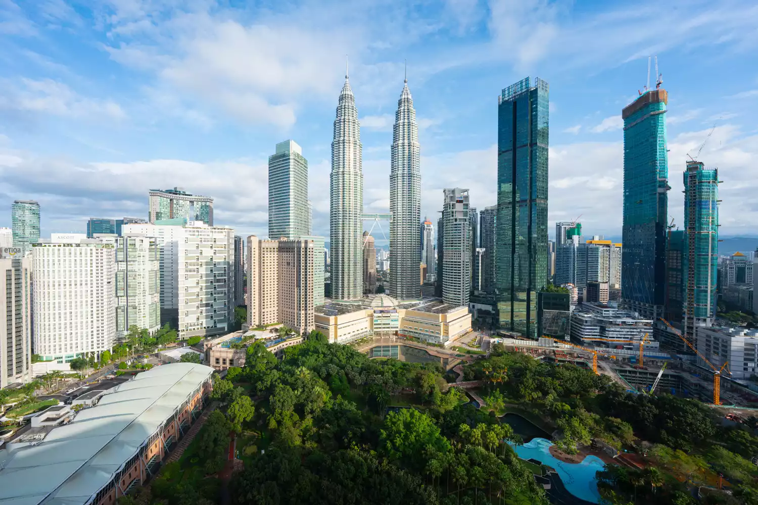 The skyline of Kuala Lumpur at dawn showing the Petronas Towers and modern skyscrapers.