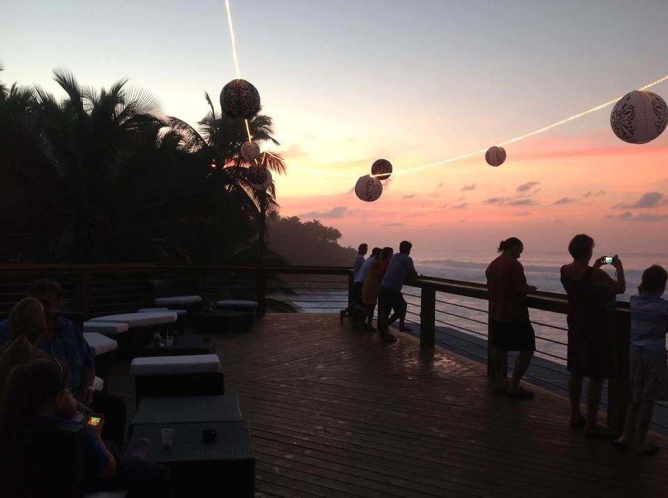 Breezy outdoor deck of Tamboo Bar & Seaside Grill overlooking a surf beach in Rincón.