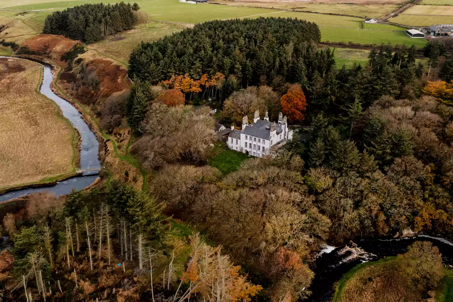 Aerial view of the Forss House Hotel surrounded by lush woodlands near the northern coast.