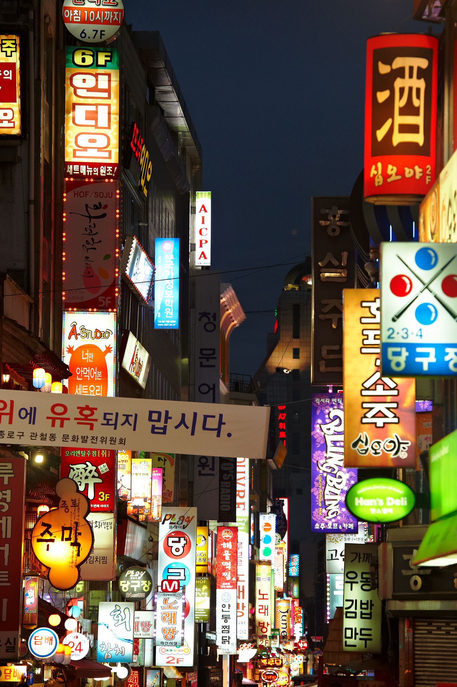 Urban city architecture at night with street-level lighting and building facades.