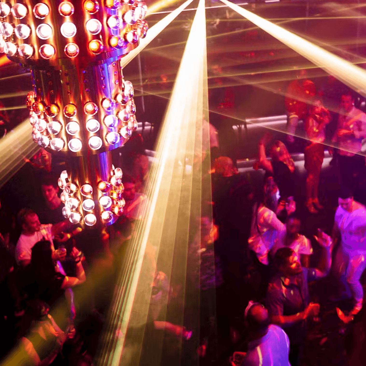The interior of a high-energy nightclub with neon lights and a crowd on the dance floor.