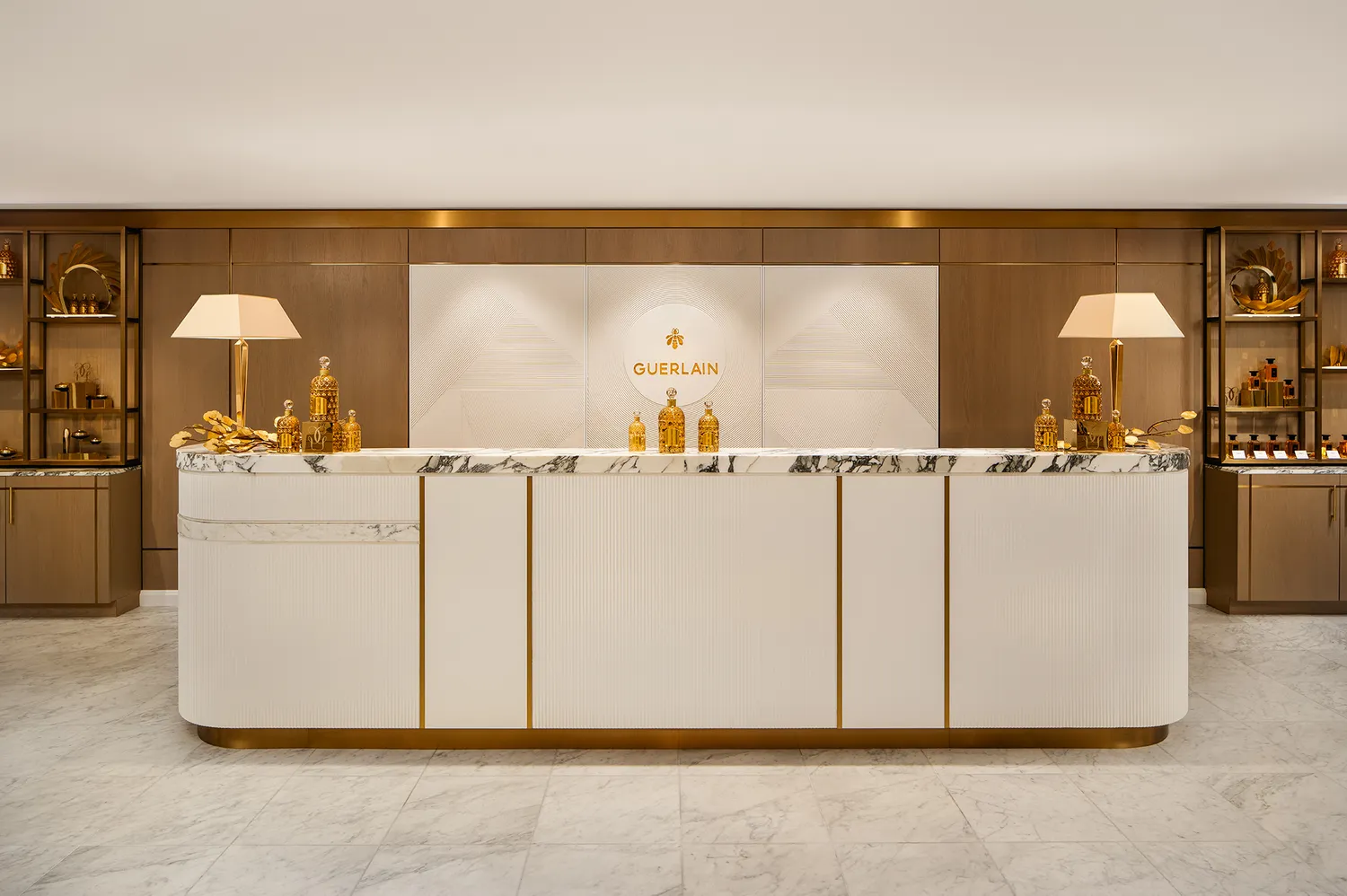 The marble reception desk at the Guerlain Wellness Spa with gold accents and high-end lighting.