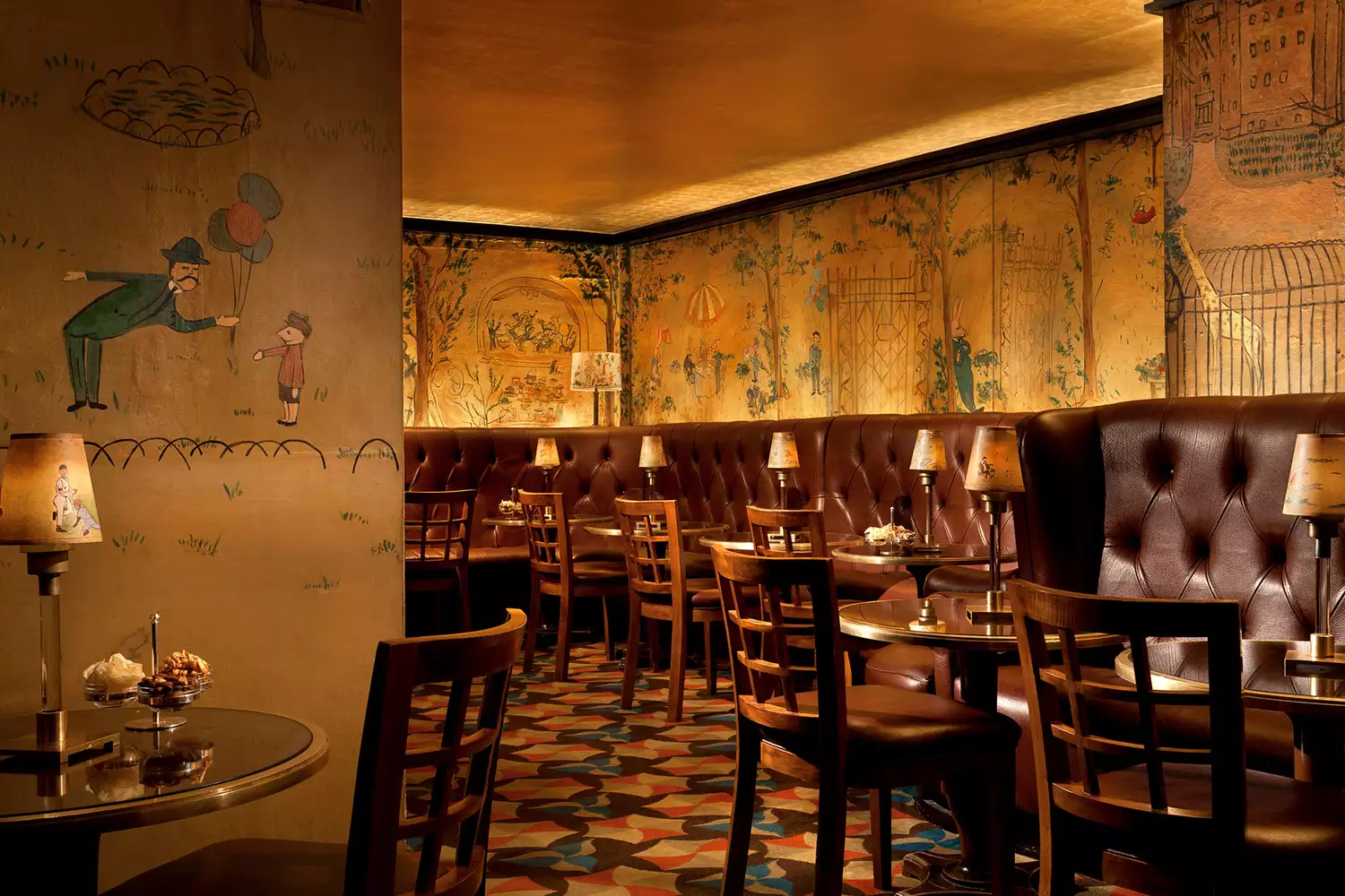 The moody, mural-covered interior of Bemelmans Bar at The Carlyle hotel.