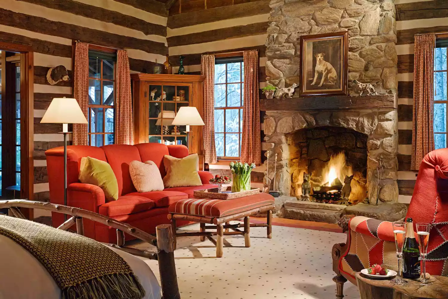 Rustic yet refined log cabin interior with a fireplace at Twin Farms in Vermont.