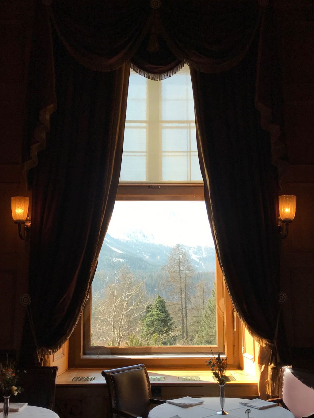 Elegant interior decor with rich curtains inside a grand Swiss mountain hotel.