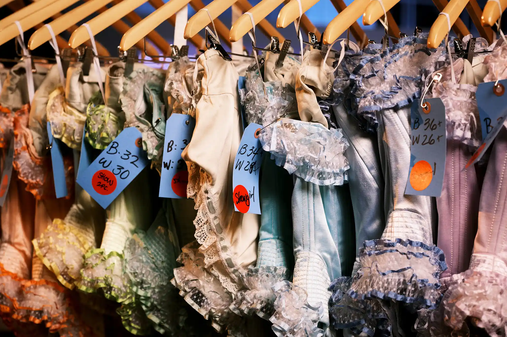 Lace dresses hanging on wooden hangers ready for a vintage-style photoshoot.