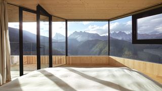 Modern wood-clad architecture nestled within a dense, misty pine forest.