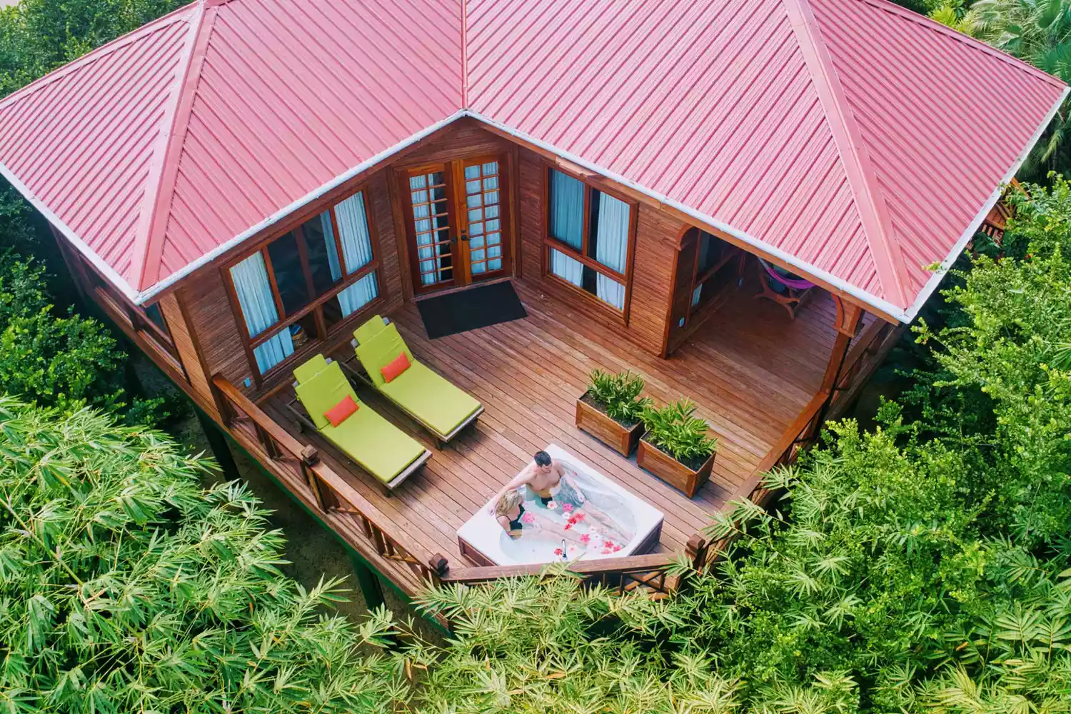 A deluxe wooden treehouse at Hamanasi Adventure & Dive Resort surrounded by thick jungle foliage.