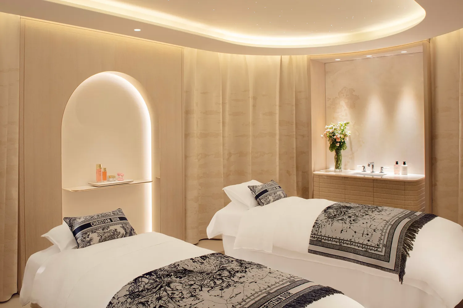 A treatment room at the Dior Spa with two massage beds and elegant minimalist decor.