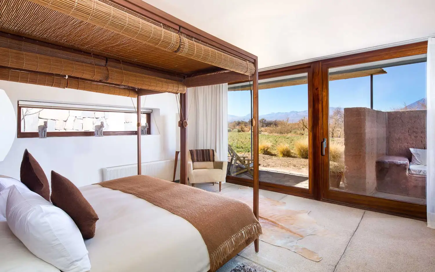 A luxury guest room at Tierra Atacama with simple wooden furniture and neutral tones.