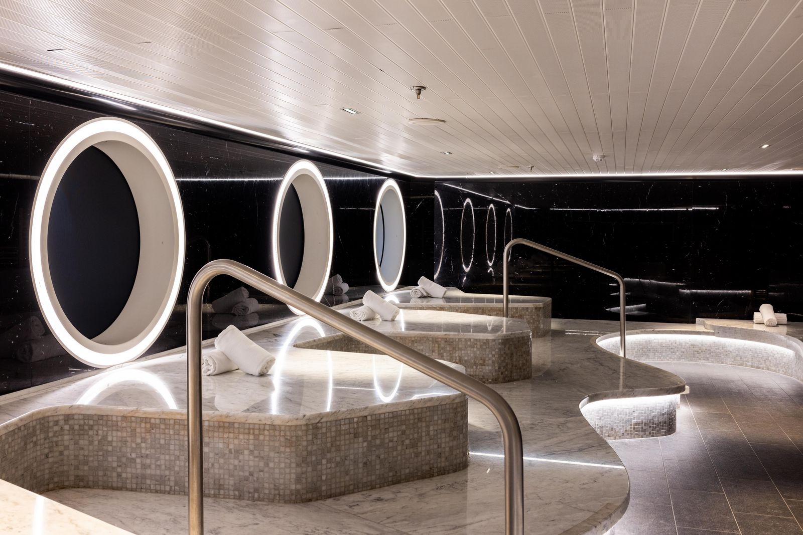 Interior shot of a high-end cruise ship bathroom featuring a soaking tub and modernist lighting.