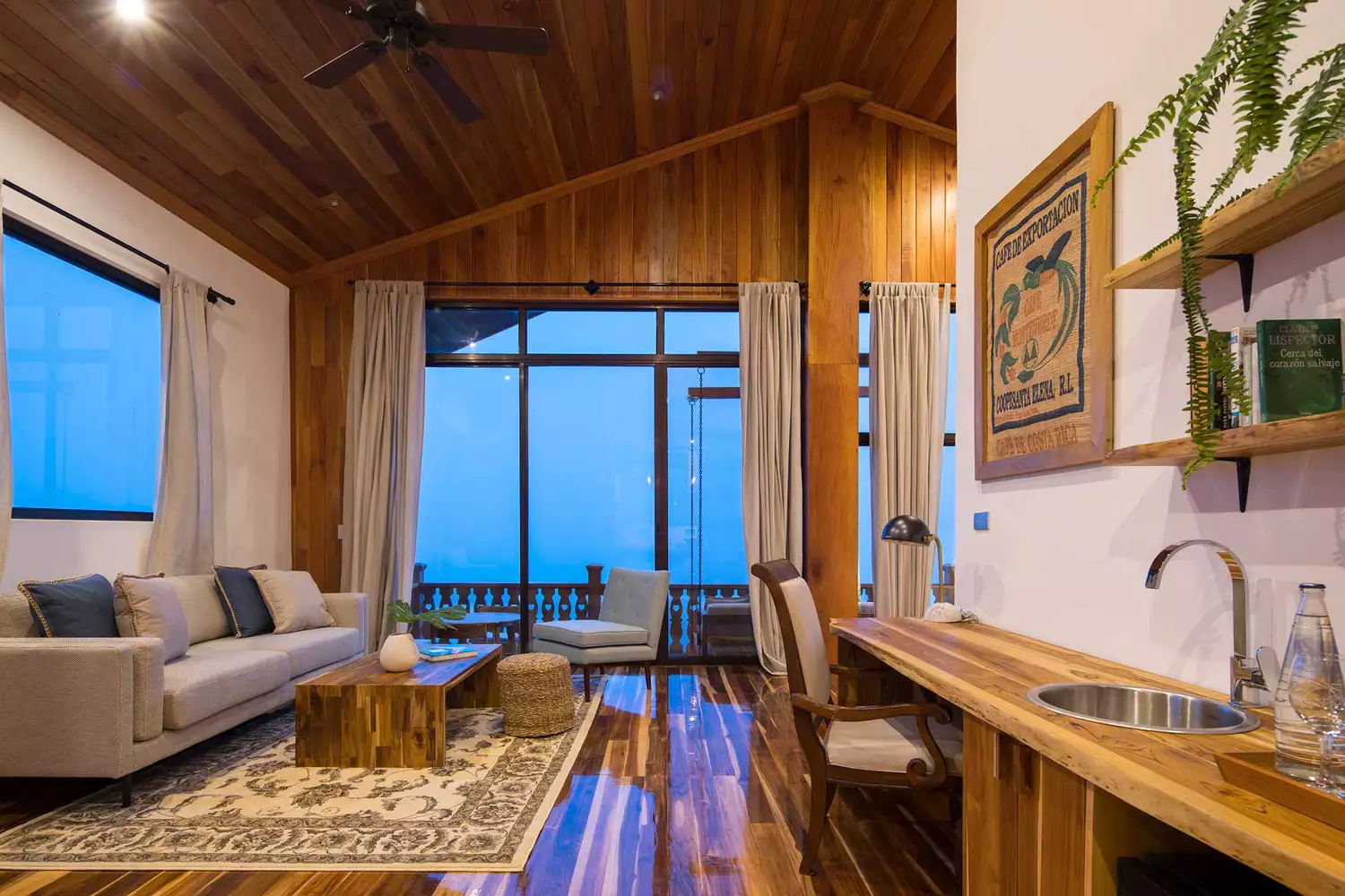 A penthouse guest room at Hotel Belmar with large windows facing the Monteverde cloud forest.