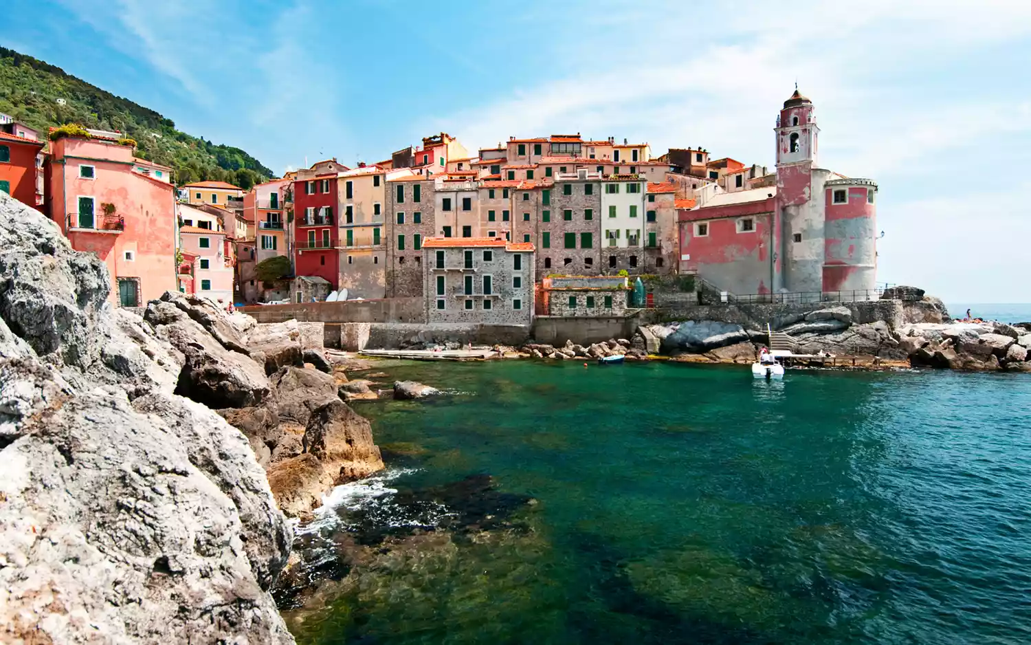 Colorful historic buildings of Tellaro, Italy along the rocky Mediterranean coastline.