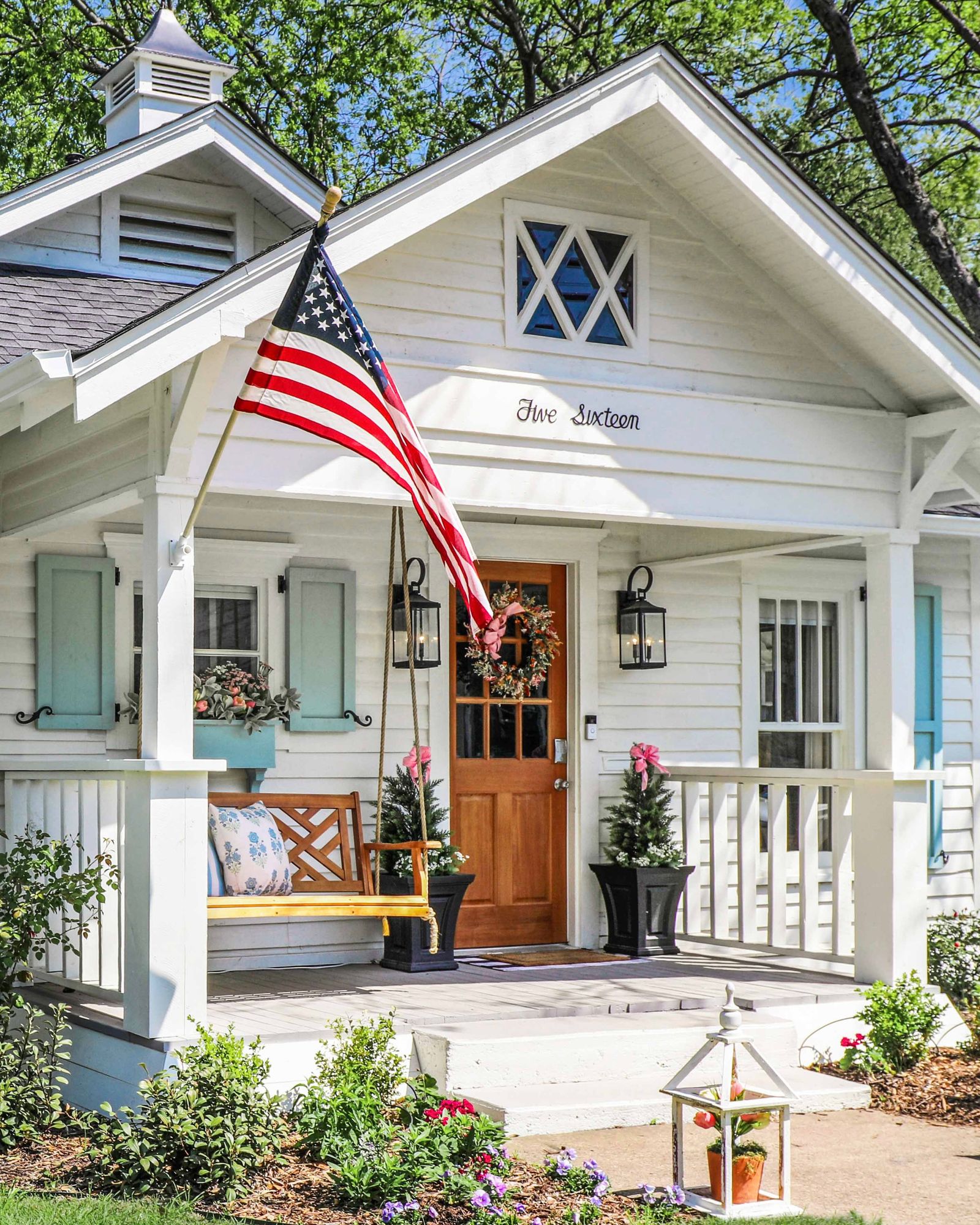 A well-maintained traditional house with a porch and flags, representing local heritage stays.