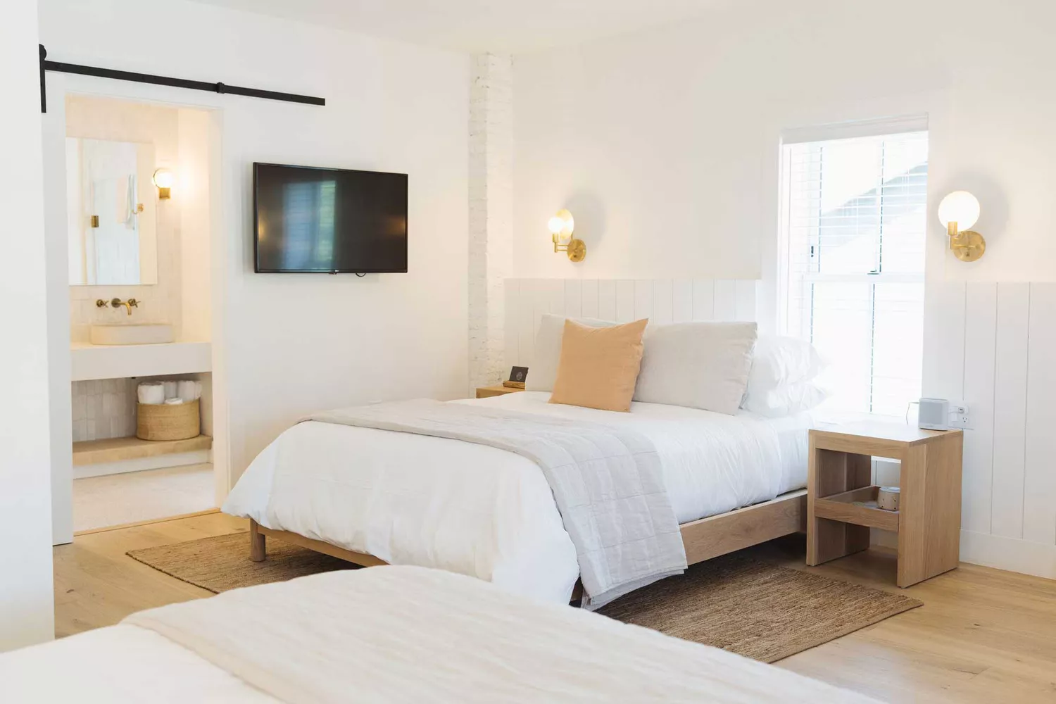 A bright, coastal-modern guest room interior at The Wildset Hotel featuring minimalist decor and soft natural lighting.