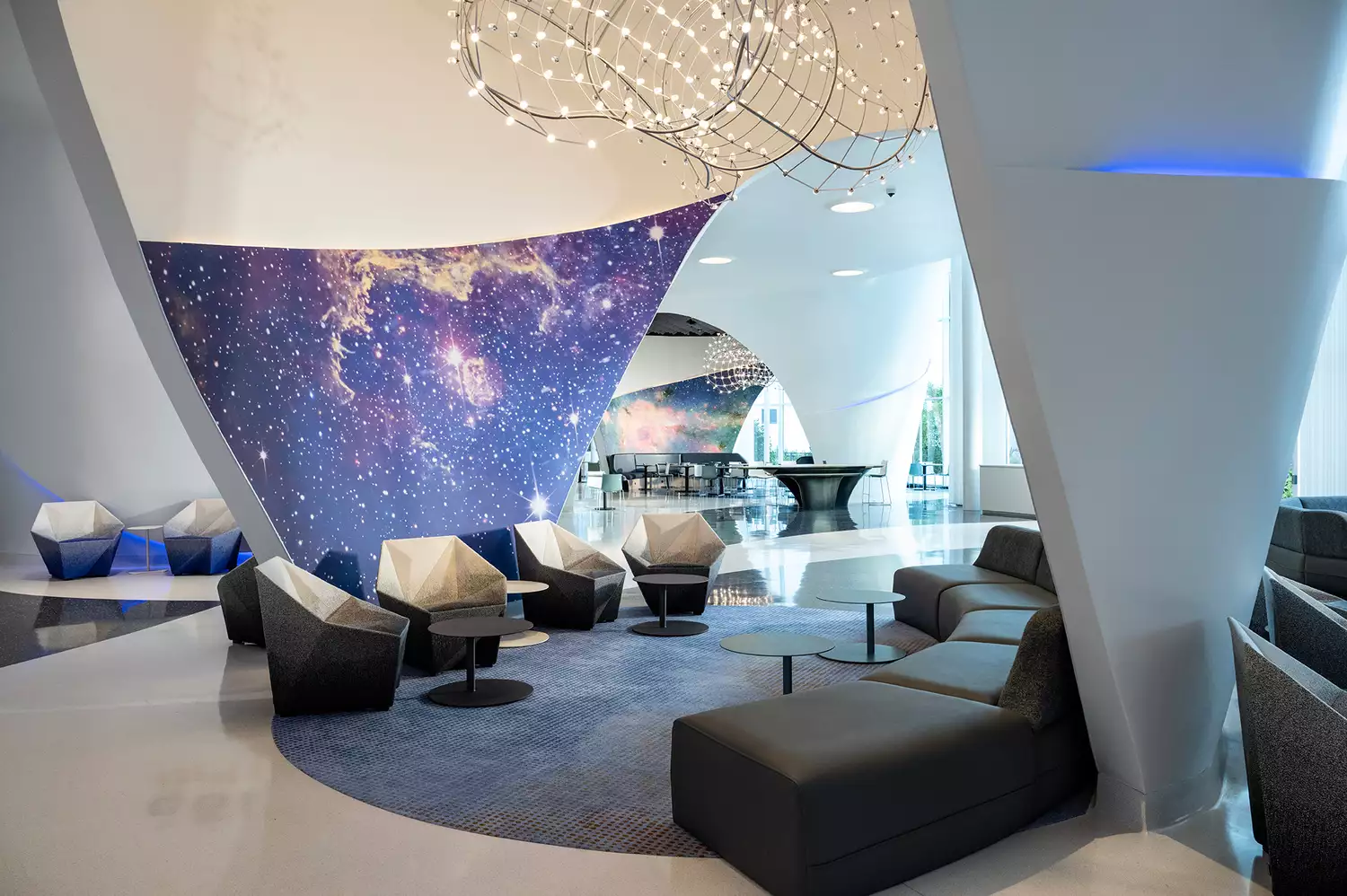 The contemporary lobby of Universal Stella Nova Resort featuring high ceilings and cosmic-themed decor.