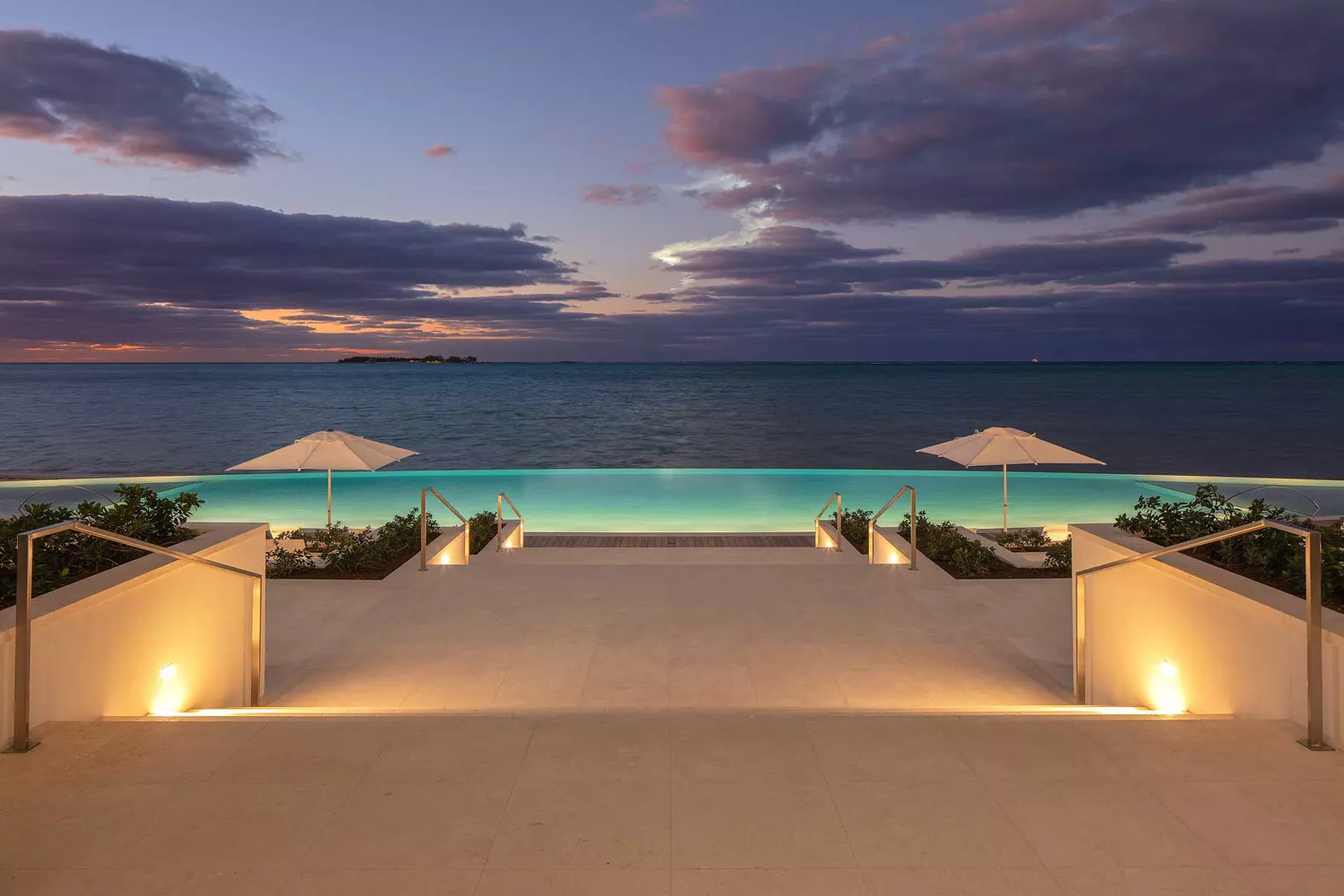 The infinity pool at Goldwynn Resort Bahamas overlooking the ocean at sunset.