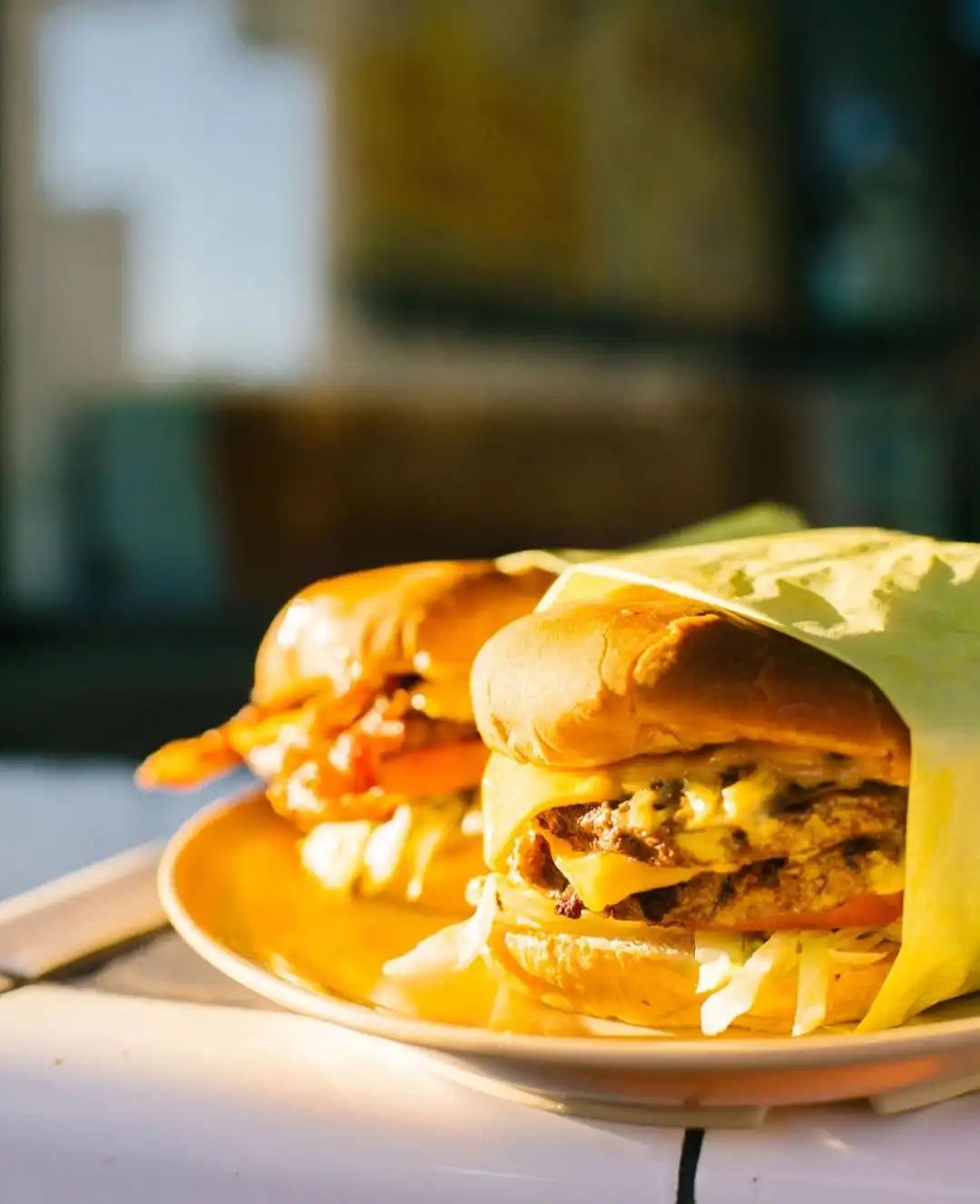 A classic cheeseburger served on a traditional plate, emphasizing the heritage diner aesthetic.