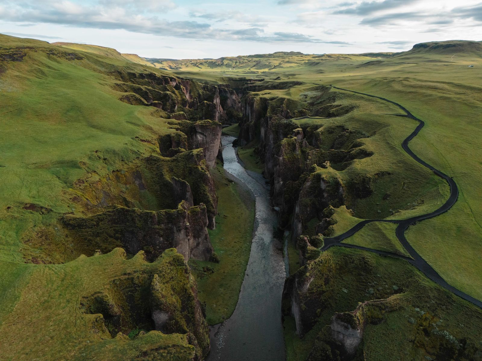 An aerial view of a winding river surrounded by dense green forest and nature.