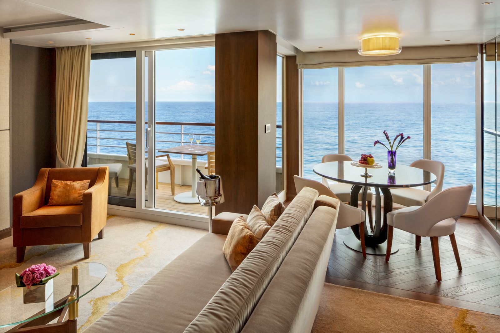 A modern luxury cruise ship balcony suite featuring designer furniture and scenic views.