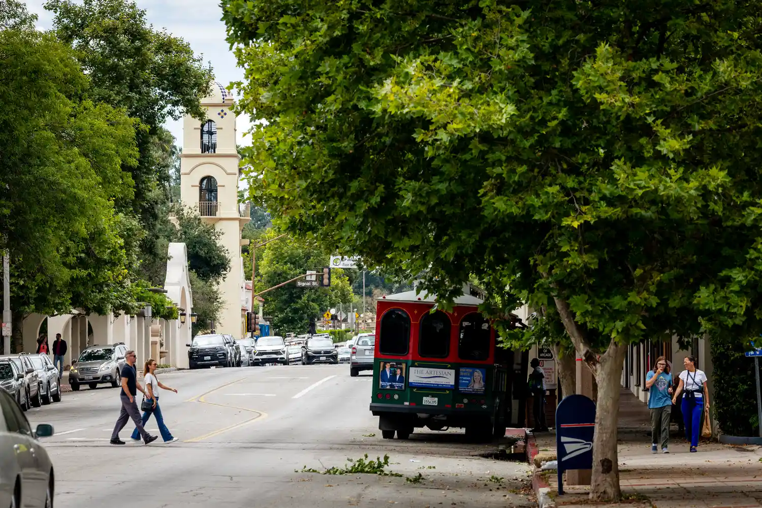 Pedestrians walking by the Spanish Colonial tower and shops in downtown Ojai.