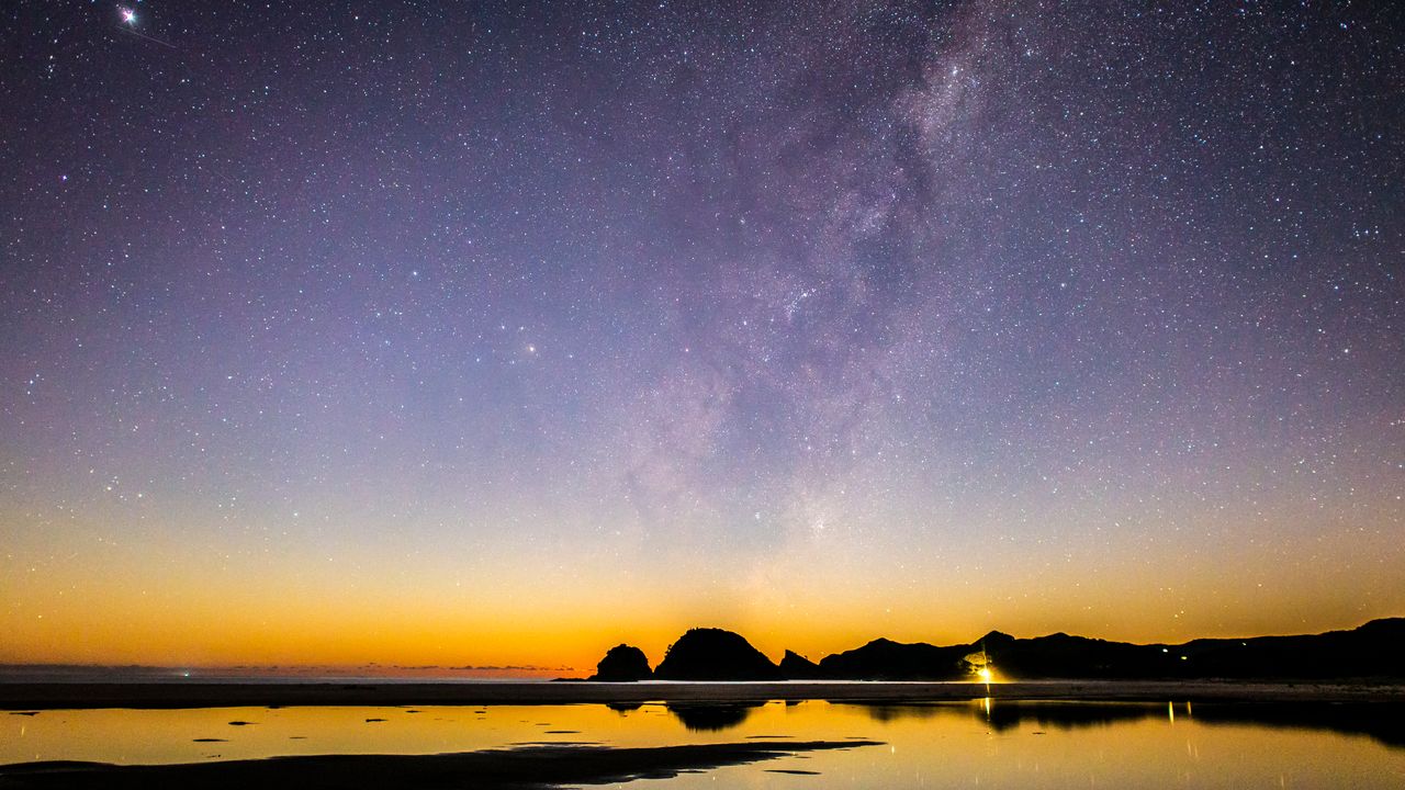 A deep-space star field over a dark horizon, showcasing maximum star visibility.