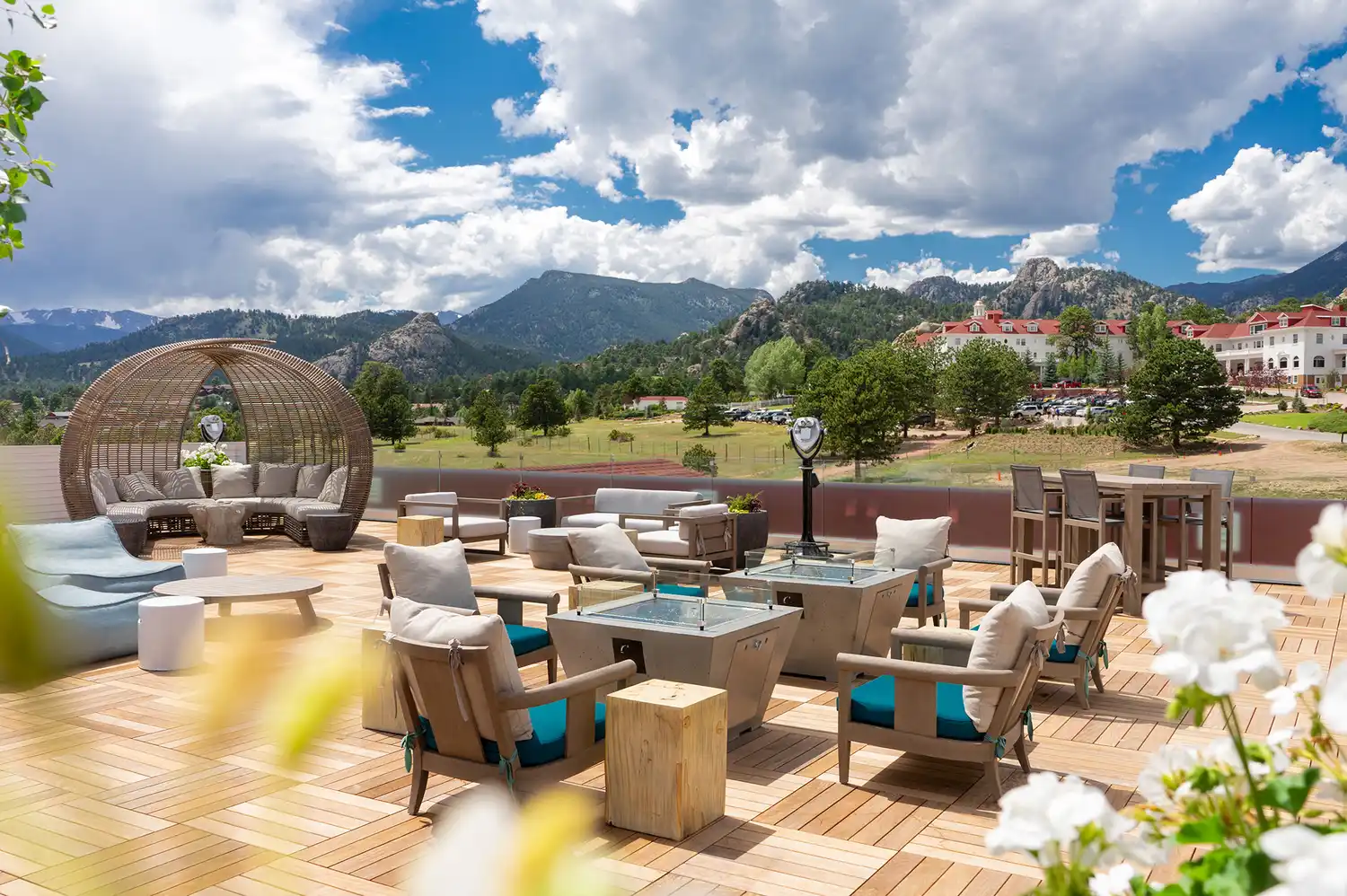 Rooftop lounge area with patio furniture looking out over the mountains and the historic hotel campus.