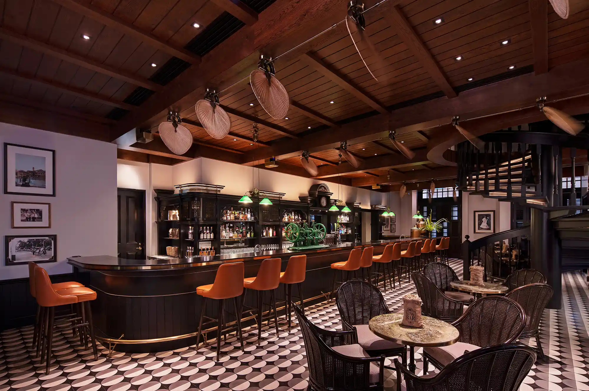 The opulent interior of a grand bar in Singapore with high ceilings and traditional wood finishes.