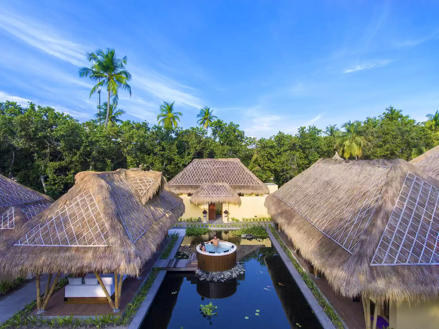 Emerald Maldives Resort overwater bungalows extending into a turquoise lagoon.