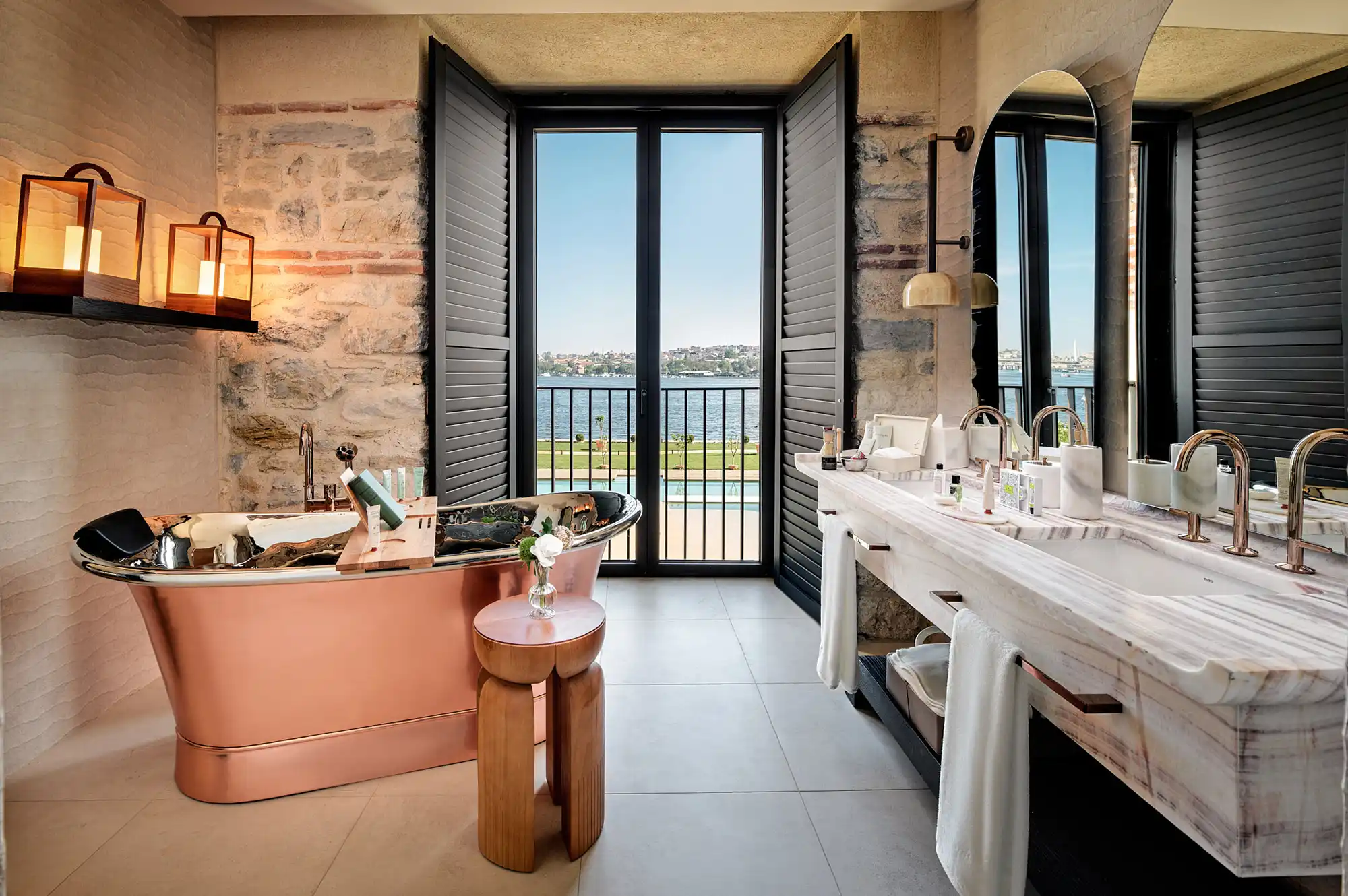 Luxurious bathroom featuring a standalone bathtub and large windows overlooking the shipyard waterfront.