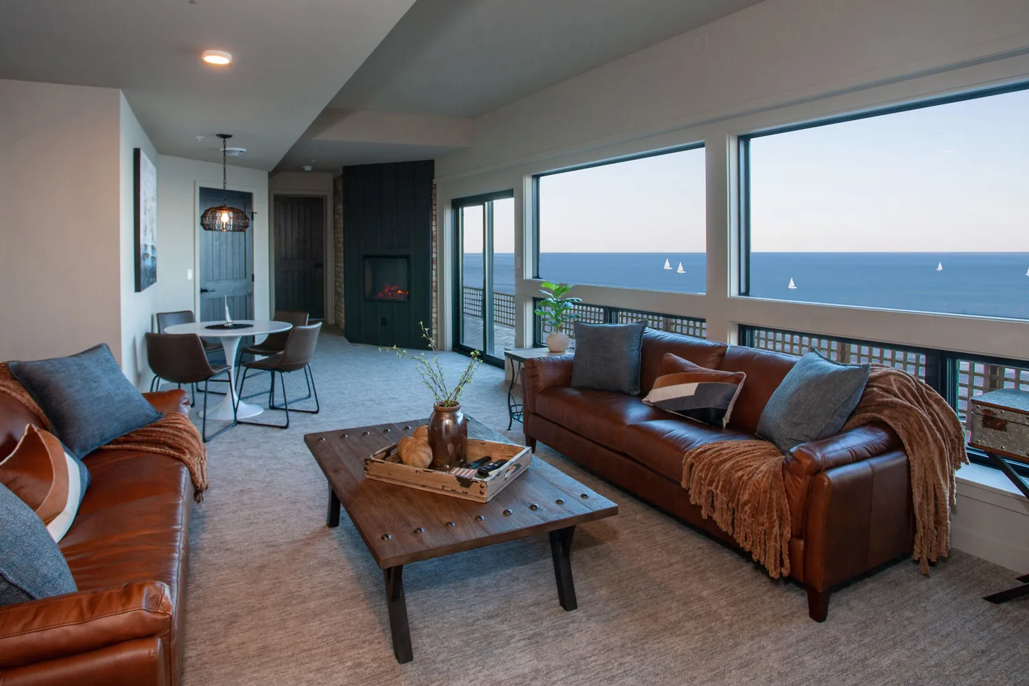 A modern boutique hotel room in Duluth featuring leather sofas, large windows with a view of Lake Superior, and contemporary decor.