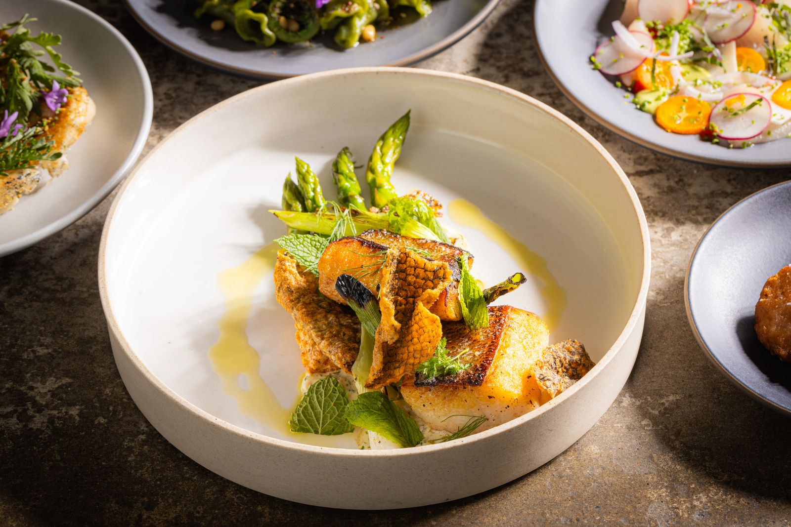 A sophisticated plate of meat and seafood with gourmet presentation.