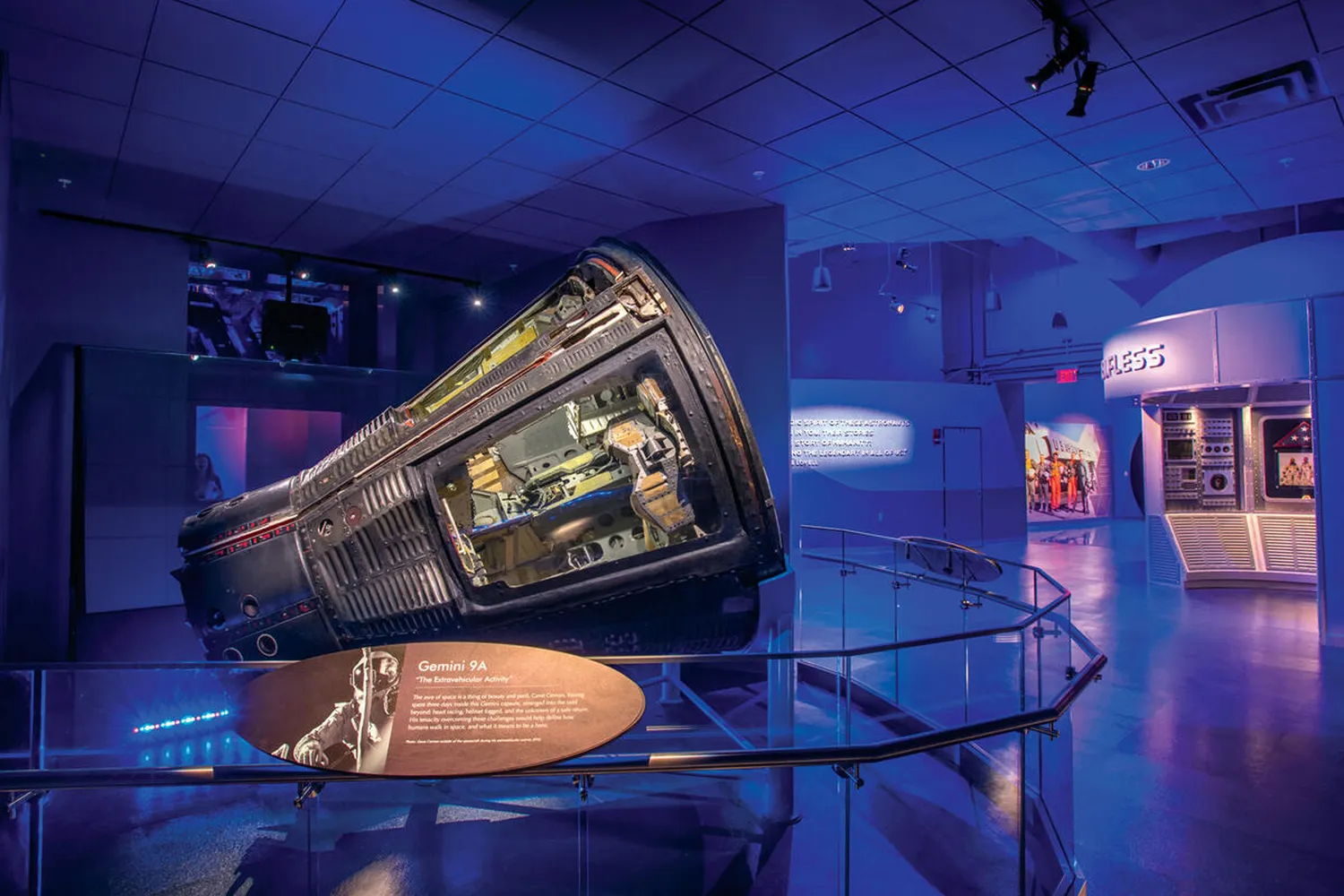 The Gemini 9A space capsule inside a dimly lit museum gallery at Kennedy Space Center.