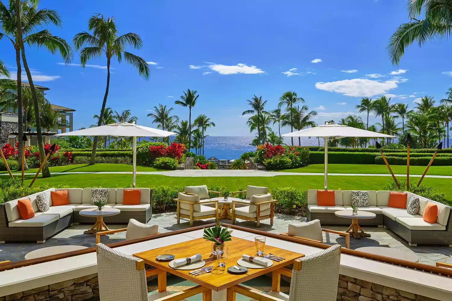 An expansive outdoor patio at Montage Kapalua Bay featuring comfortable seating and a view of the ocean.