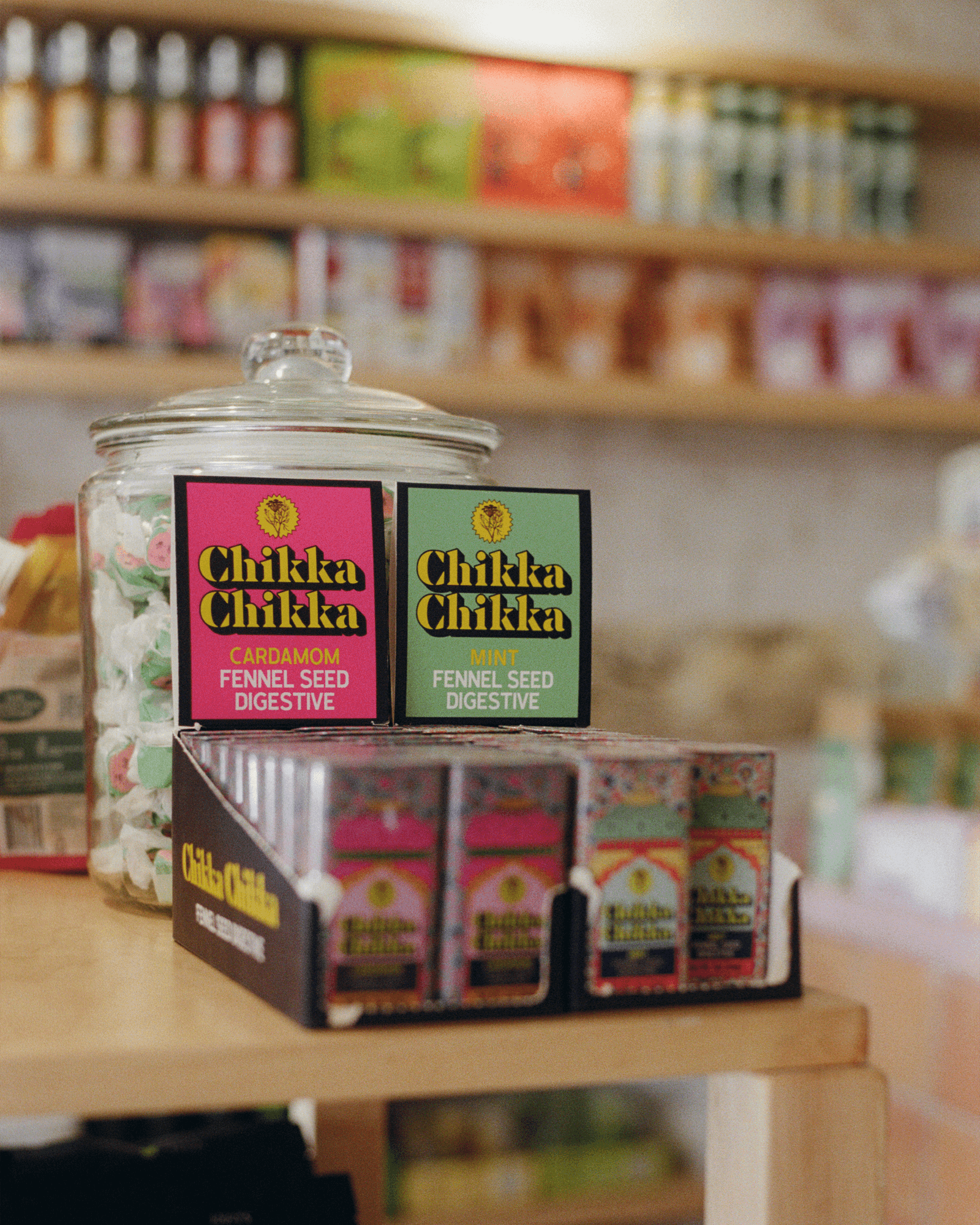 Tins and boxes of Indian sweets and ingredients stacked on a shelf.