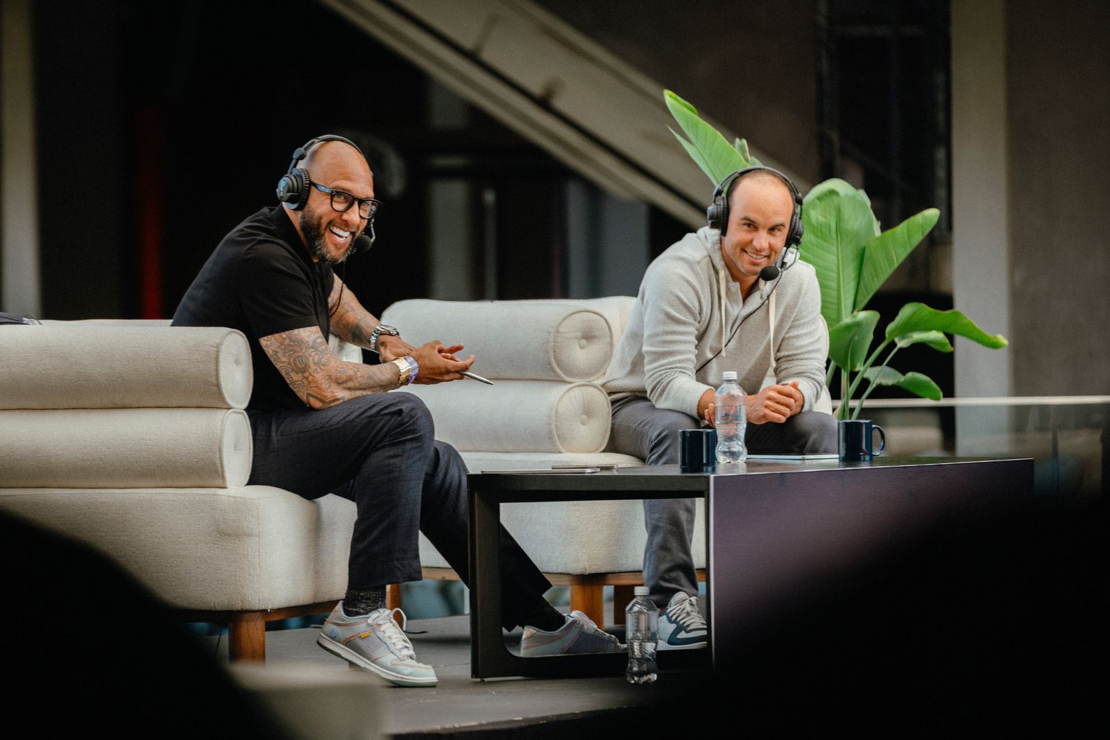 Tim Howard and Landon Donovan in a comfortable room environment having a conversation.
