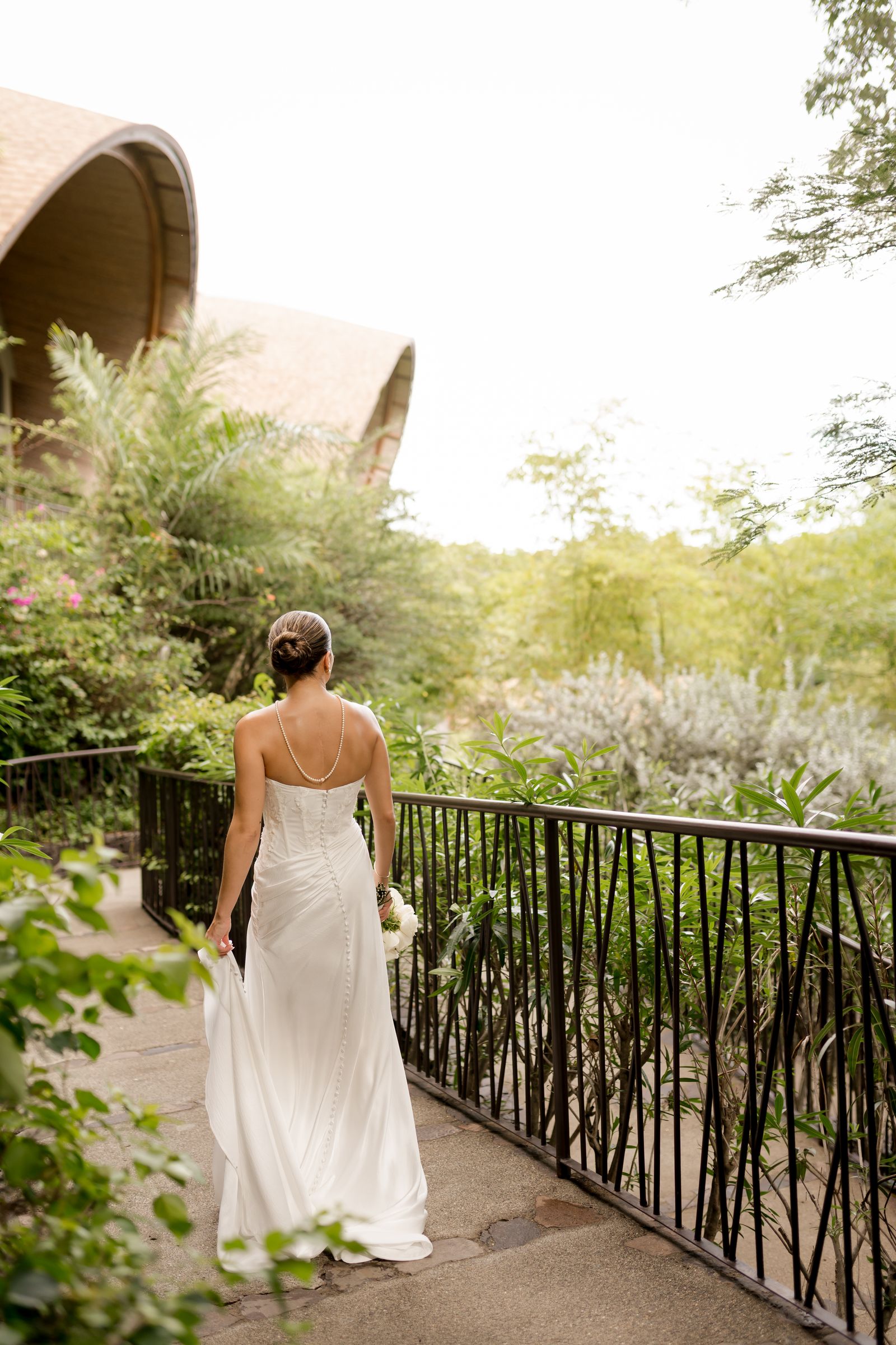 A bride in a formal wedding gown standing in an elegant setting.